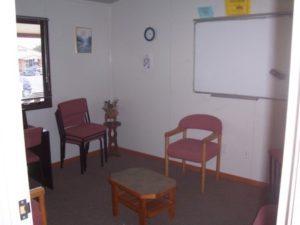Small meeting room with chairs, whiteboard and a window