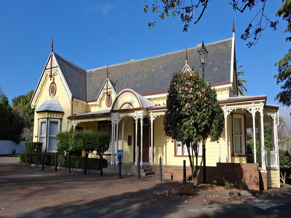 Victorian villa with yellow weatherboard and ornate gabled roofline
