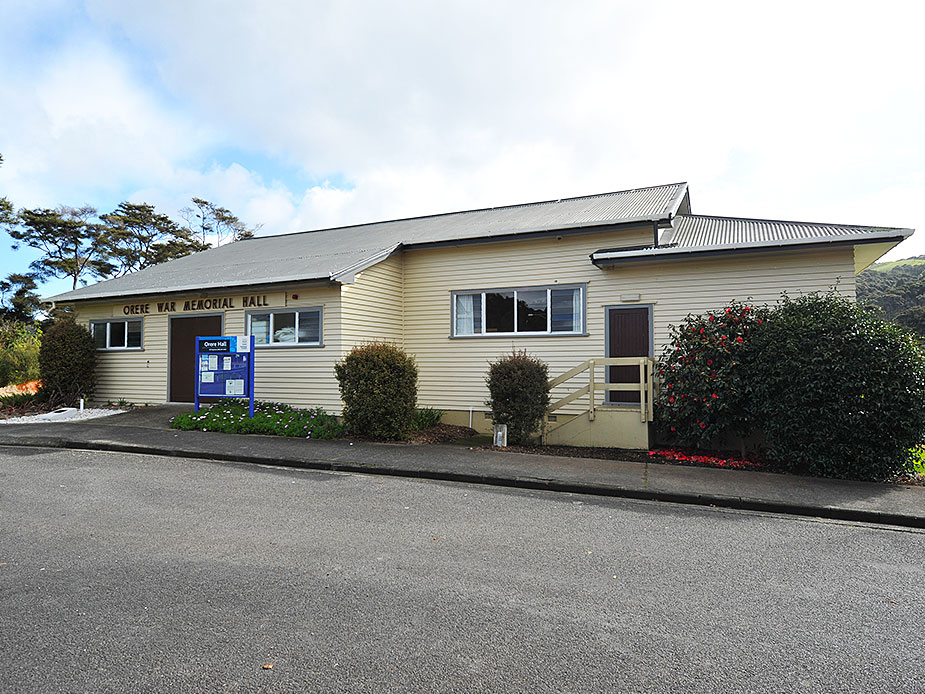 Front view of weatherboard hall with name signage and garden planting