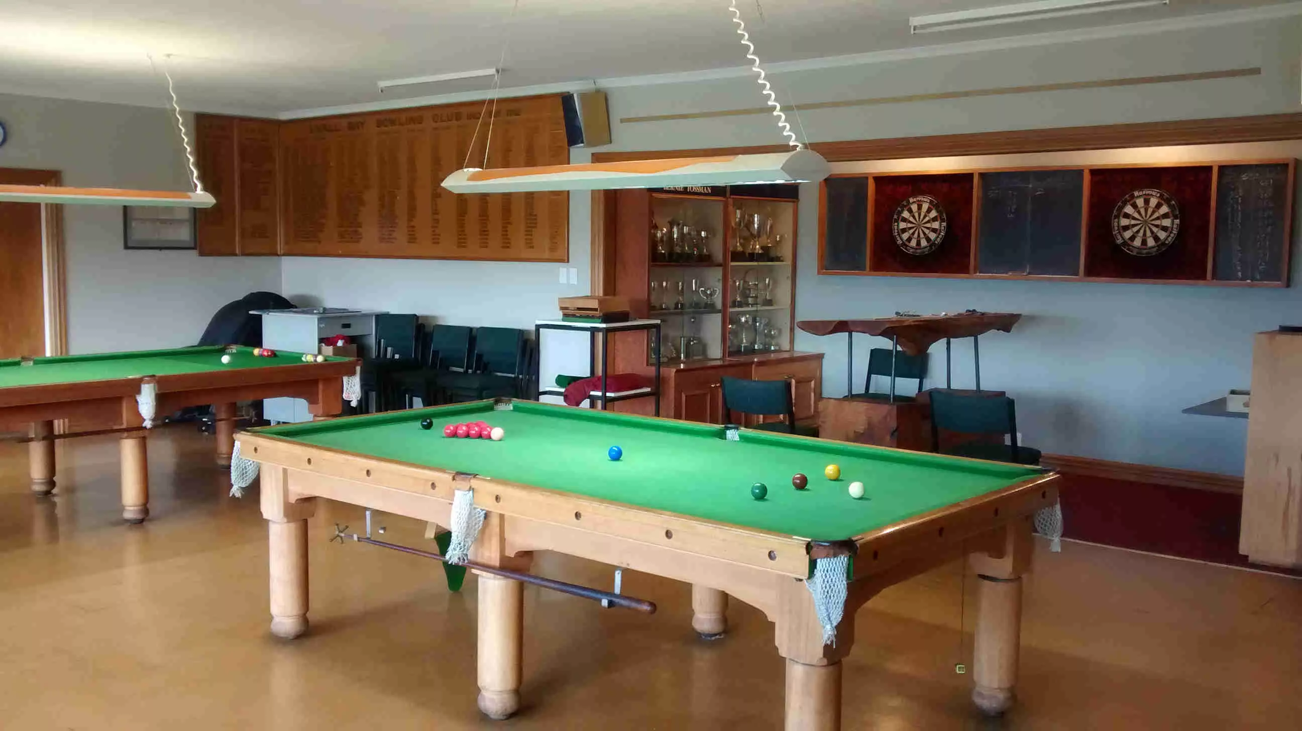 Games room with snooker tables, dartboards and trophy cabinet