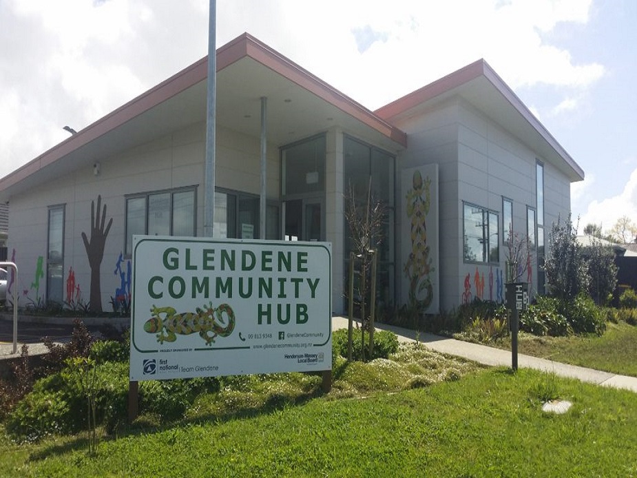 Modern community hub building with mural artwork and entry sign