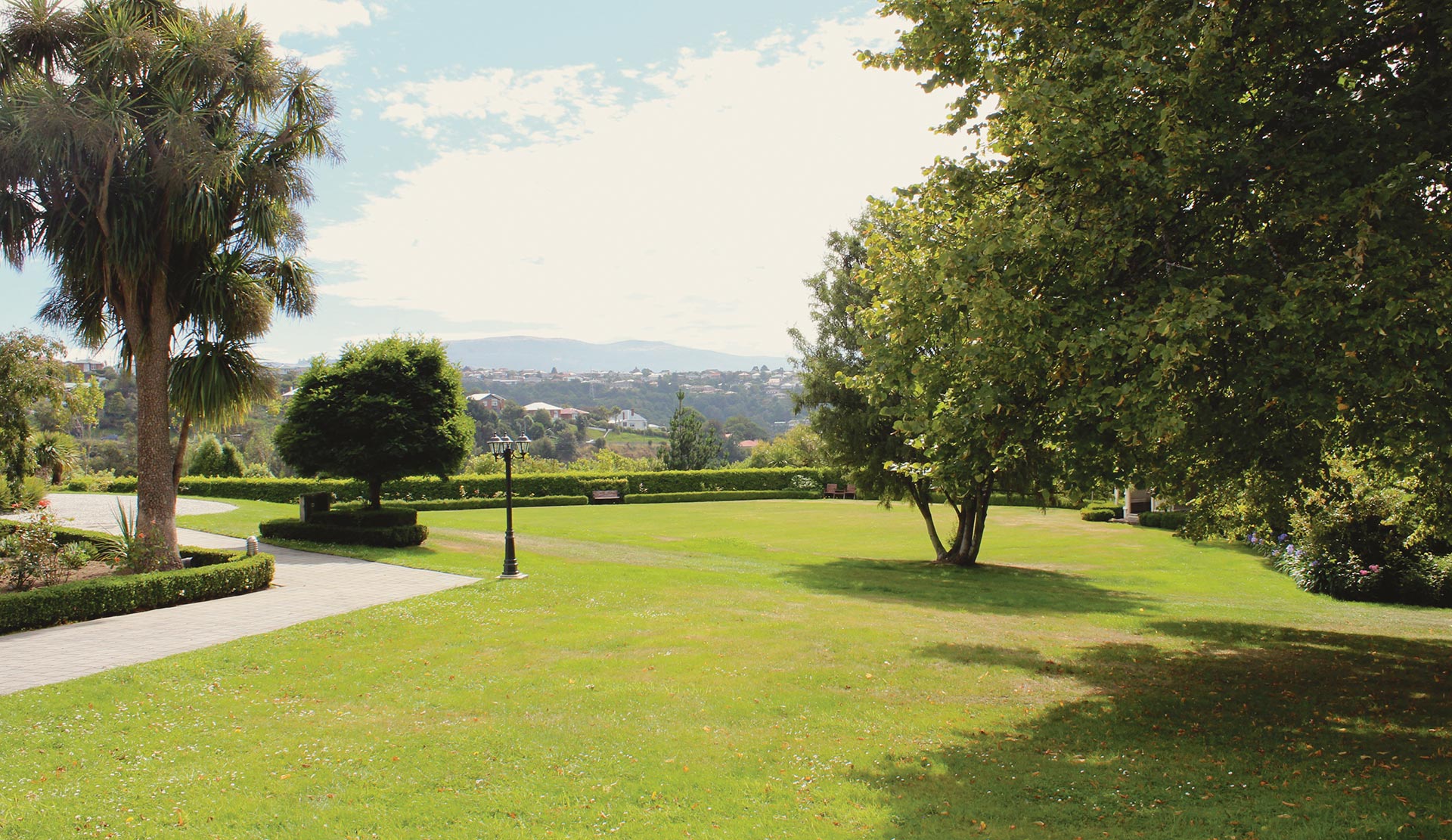 Manicured lawns and mature trees with views across the Dunedin hills