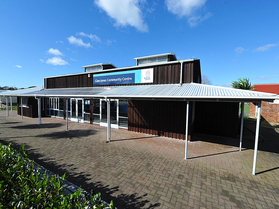 Dark brown community centre building with entrance canopy and signage
