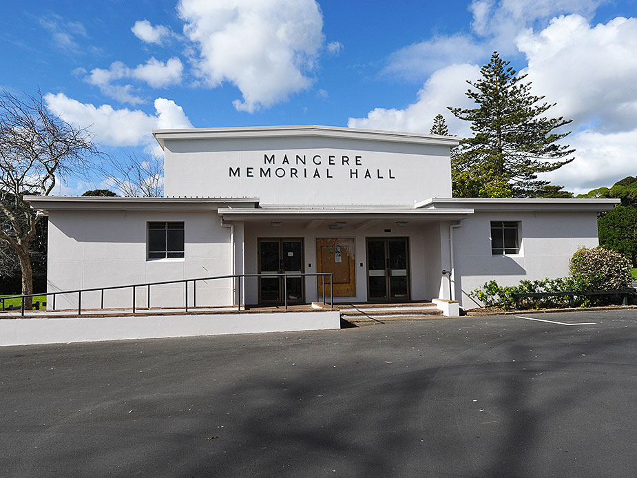 White rendered memorial hall exterior with entry steps and signage