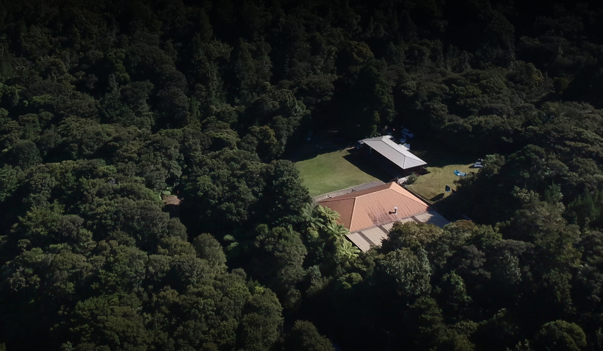 Aerial view of lodge buildings and lawn clearing in forest setting