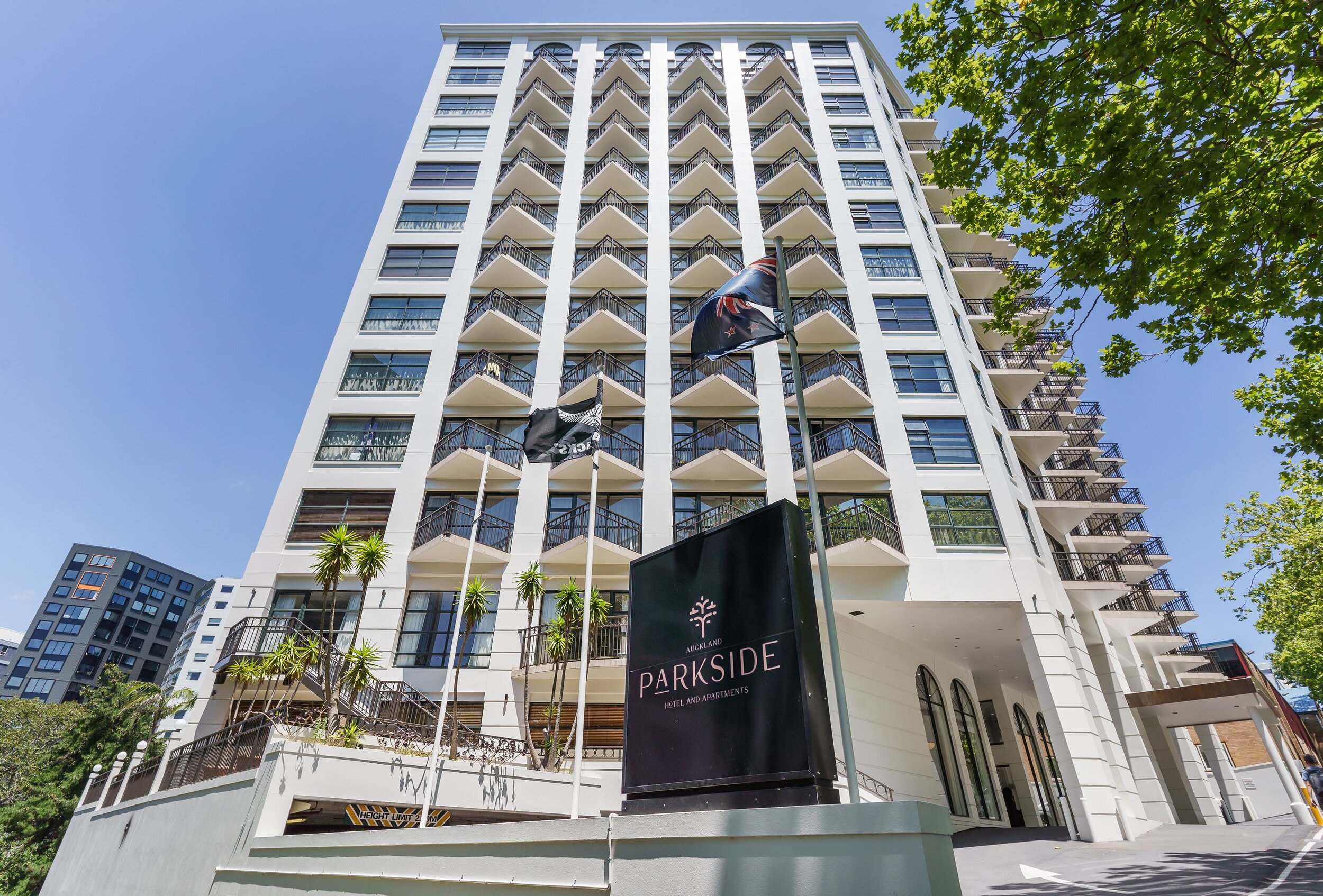Tall multi-storey hotel building exterior with flags and signage