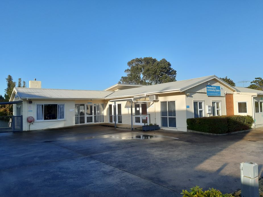 Single-storey community centre building with carpark in morning light