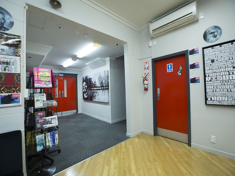 Foyer corridor with red doors, wall art, and brochure rack
