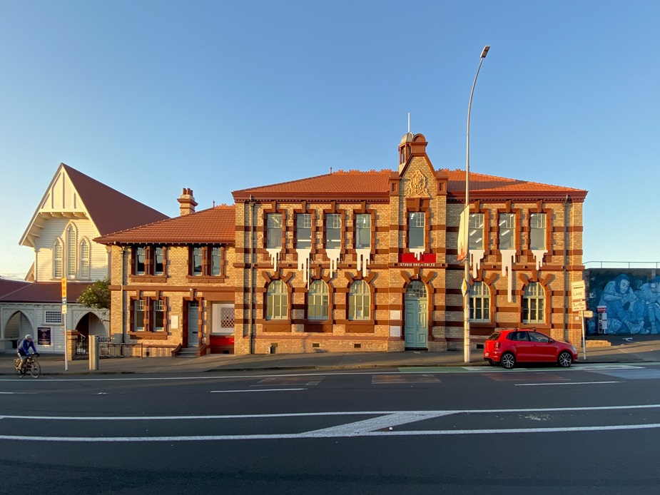 Two-storey red brick heritage building with terracotta roof tiles, street frontage