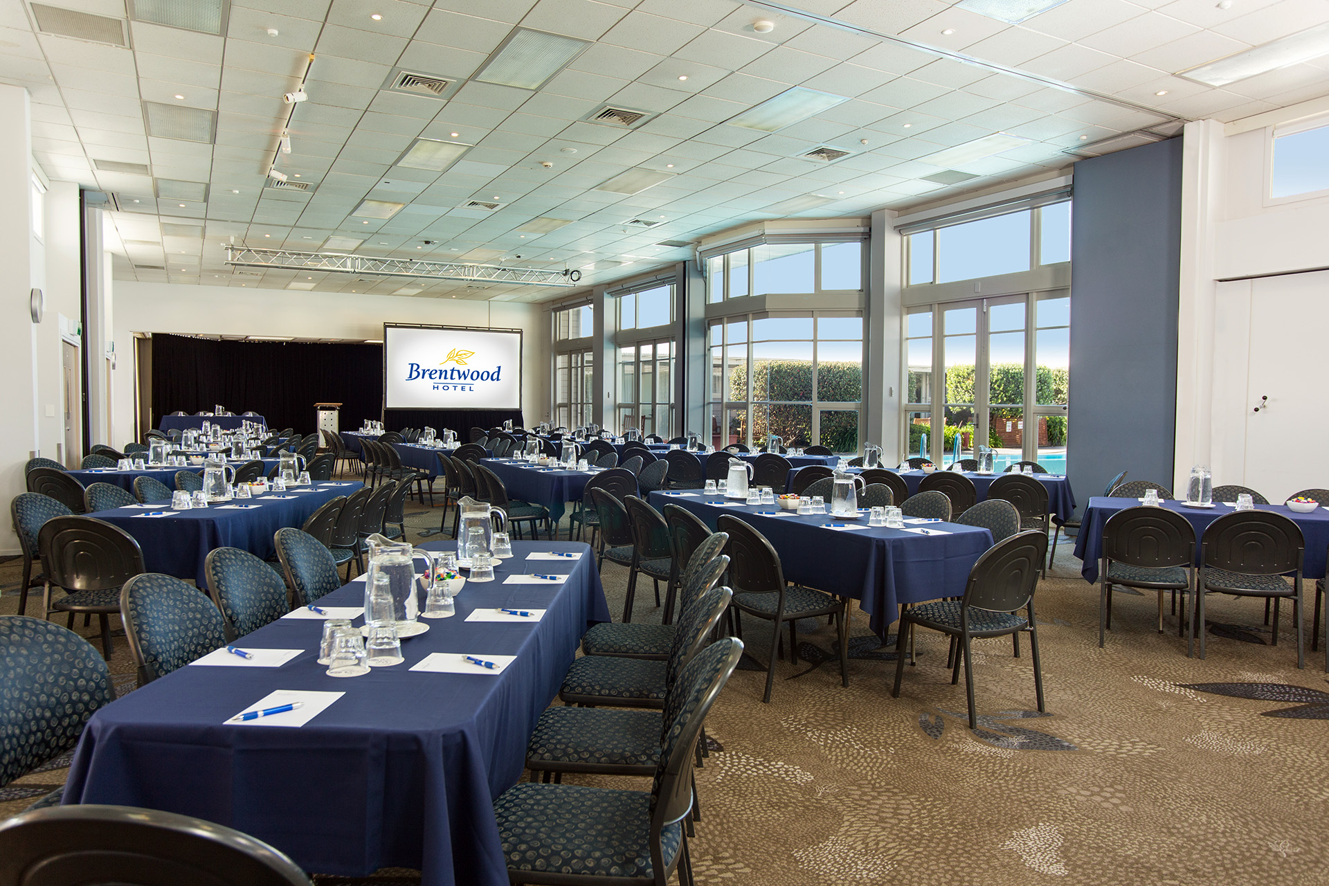 Conference room with round tables, projection screen and large windows