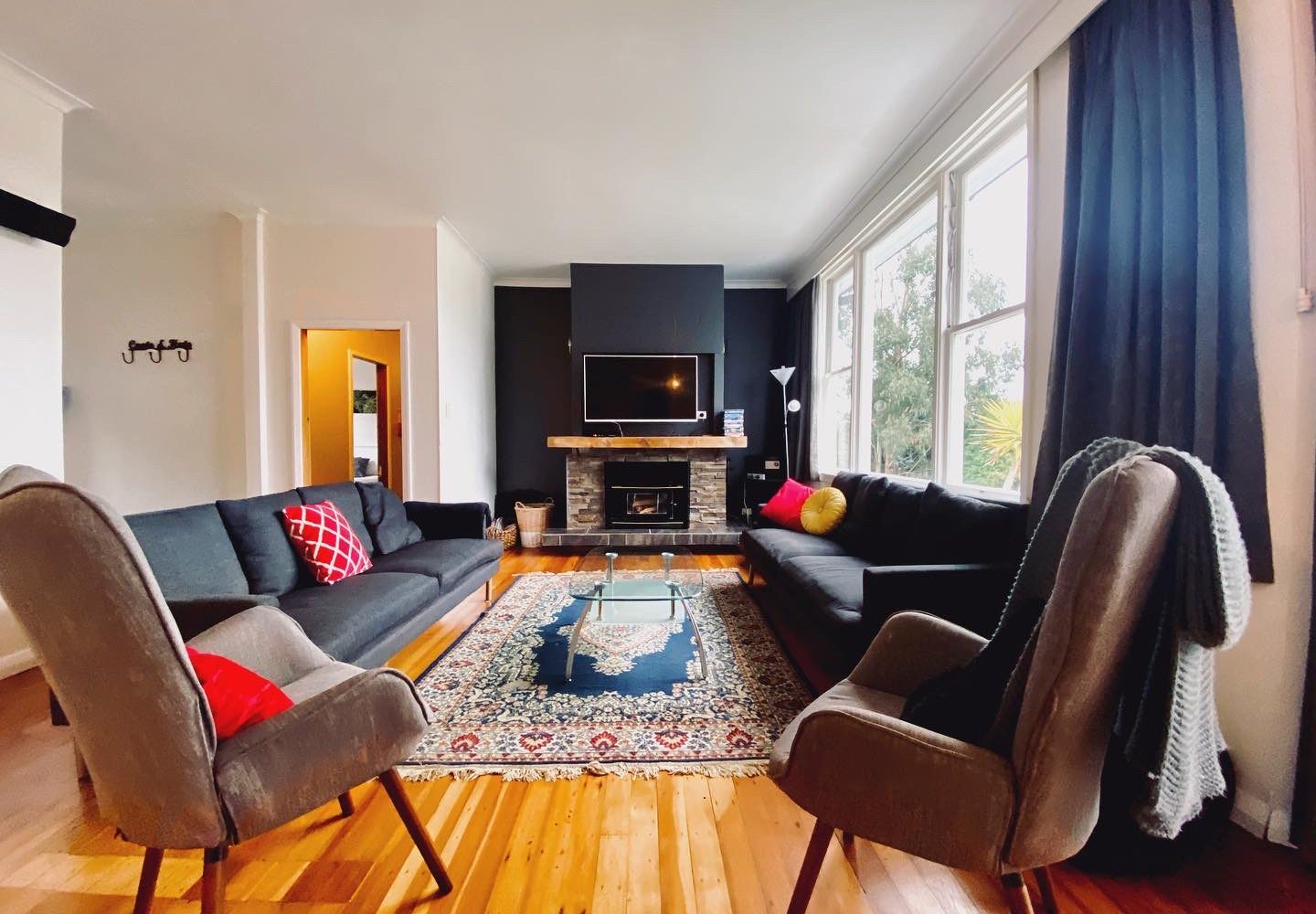 Lounge with sofas, armchairs, patterned rug and stone fireplace