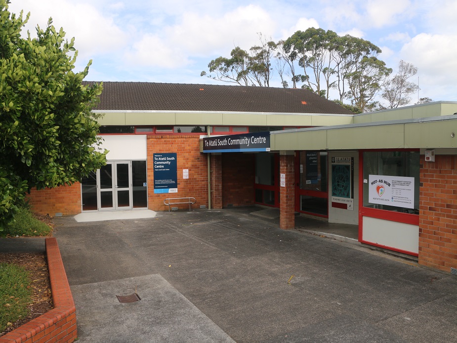Single-storey brick community centre with covered entry, ramp, and signage