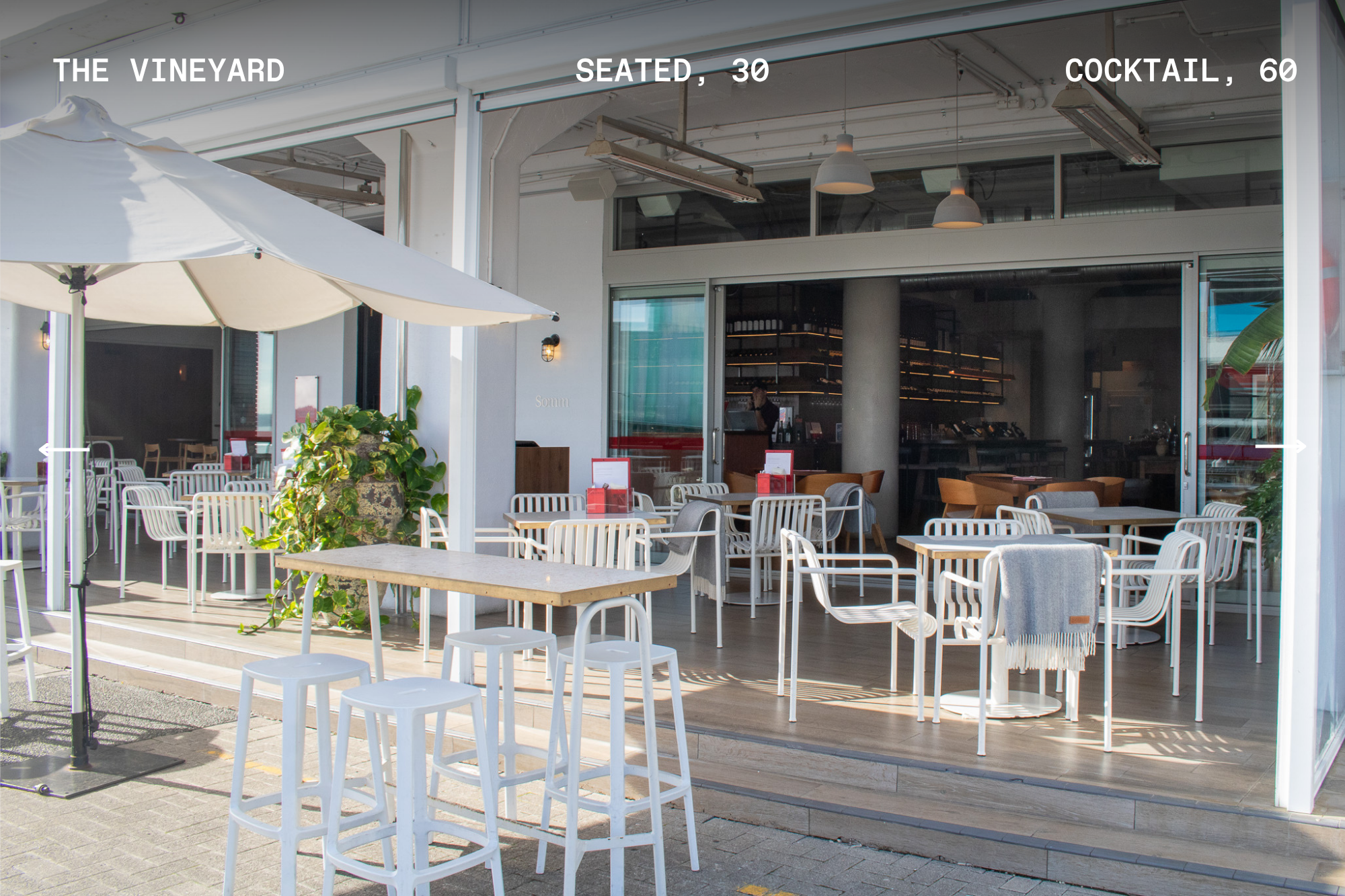 Open-air terrace dining area with white chairs and capacity text overlay